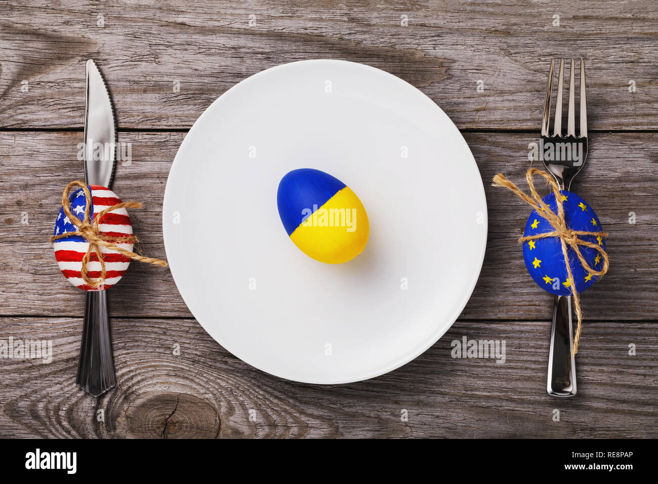 Easter egg painted in color of the flag of Ukraine in a white plate on ...