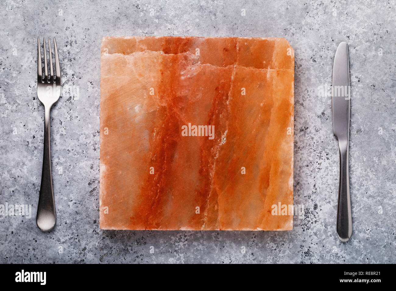 Himalayan salt tile for cooking meat dishes on the table, top view