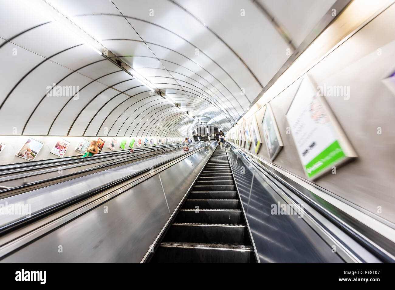 London, UK - June 26, 2018: People riding escalator up and down standing in Underground tube metro in Pimlico Victoria area of city through tunnel Stock Photo