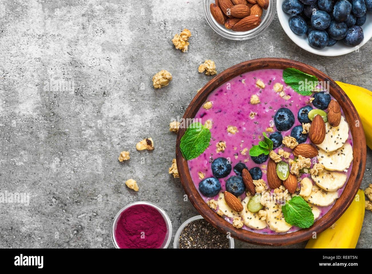 Smoothie bowl with fresh berries, nuts, seeds and homemade granola for healthy vegan vegetarian diet breakfast. top view with copy space Stock Photo