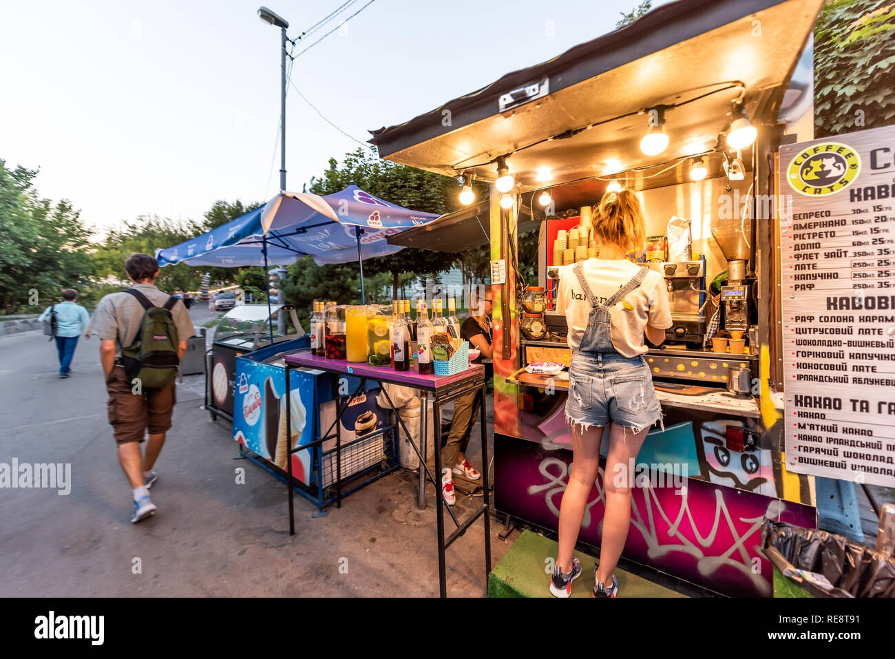 Kyiv, Ukraine - August 10, 2018: Kiev capital city during evening night with people on street in park by road ordering coffee from food stand during s Stock Photo