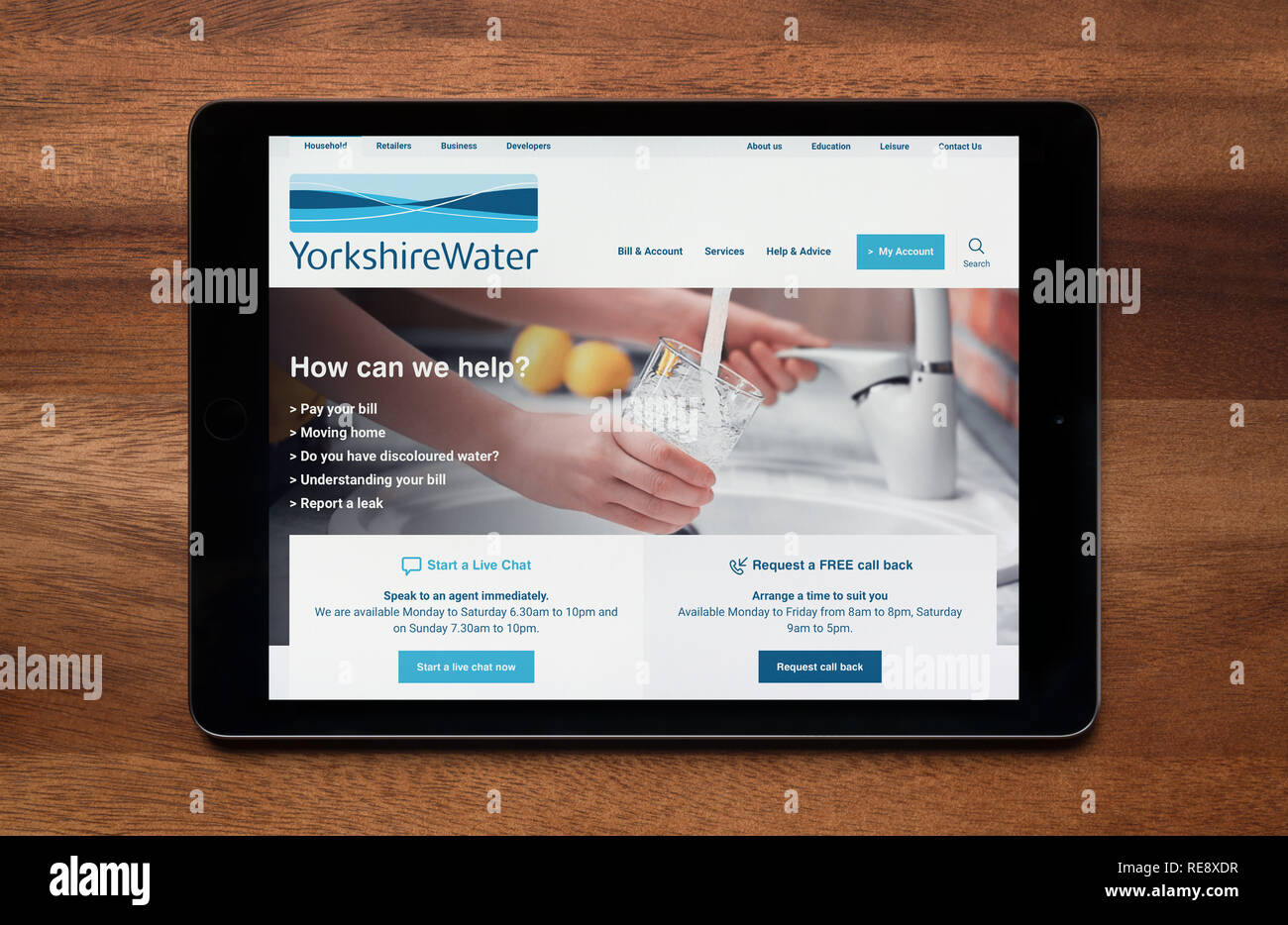 The website of Yorkshire Water is seen on an iPad tablet, which is resting on a wooden table (Editorial use only). Stock Photo