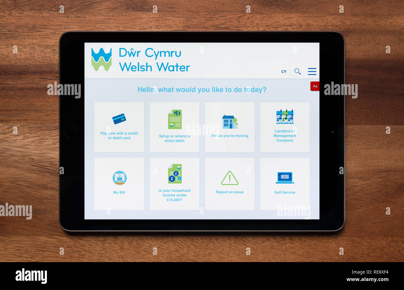 The website of Welsh Water is seen on an iPad tablet, which is resting on a wooden table (Editorial use only). Stock Photo