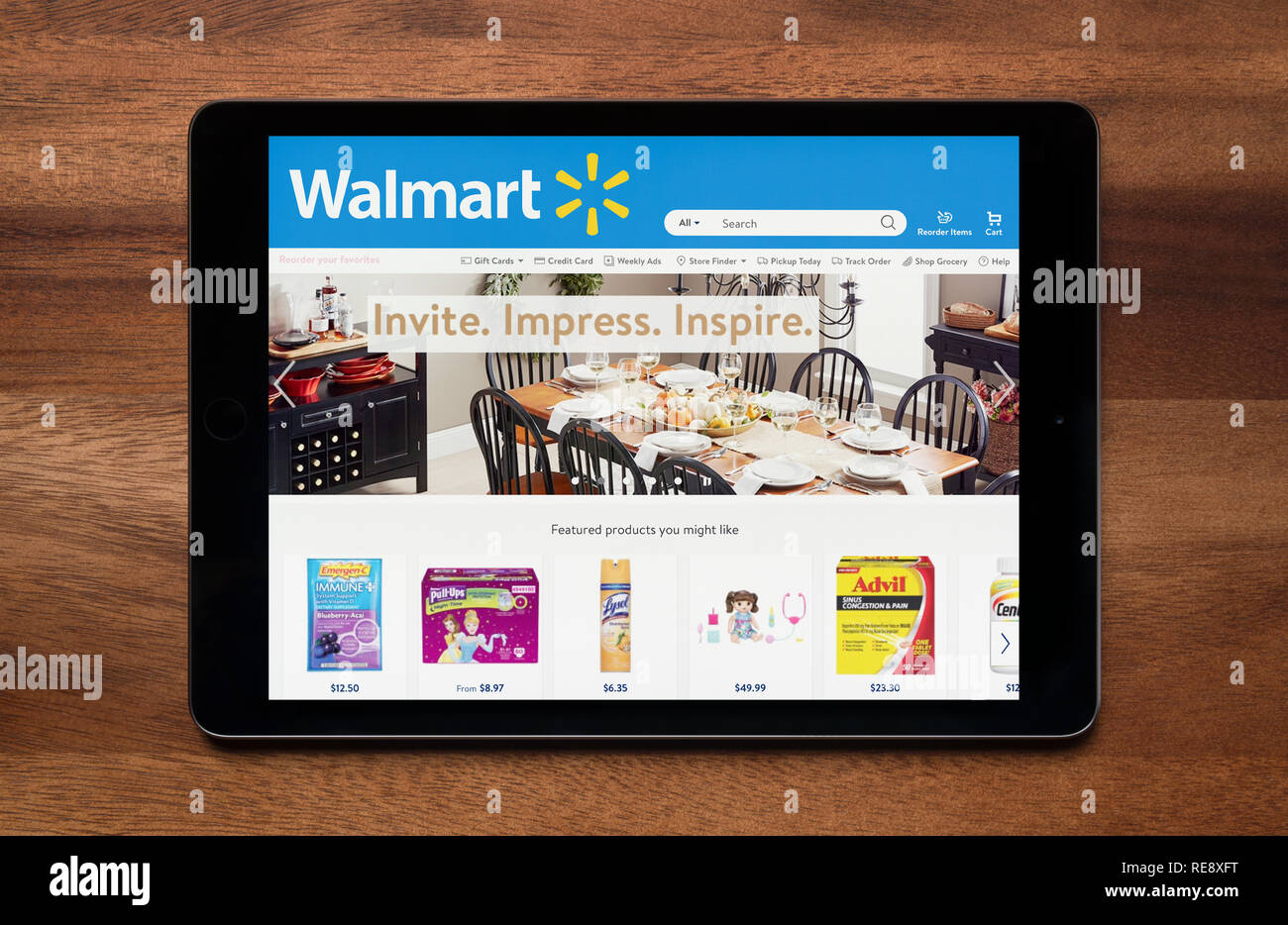 The website of Walmart is seen on an iPad tablet, which is resting on a wooden table (Editorial use only). Stock Photo