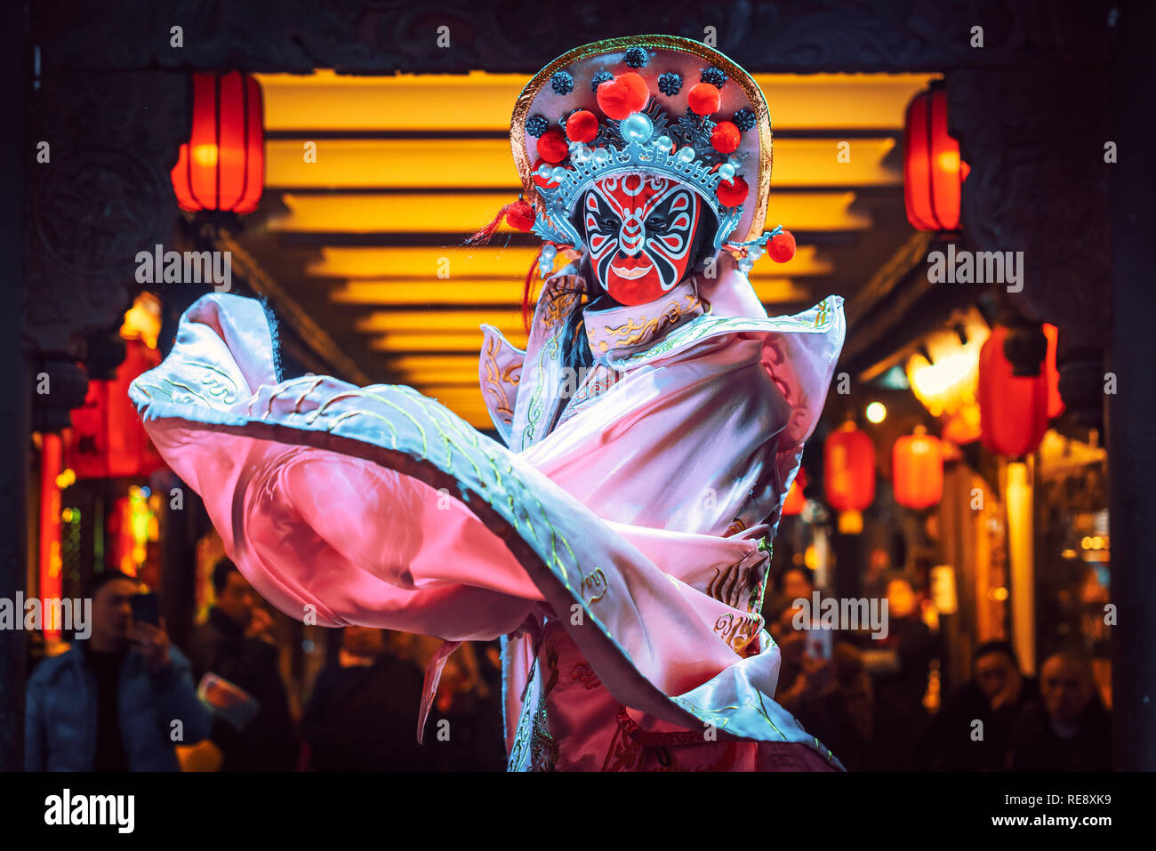 Chengdu, Sichuan Province, China - Jan 19, 2019: Chinese actress performs a public traditional face-changing art or bianlian onstage at Chunxifang Chunxilu covered street. Stock Photo