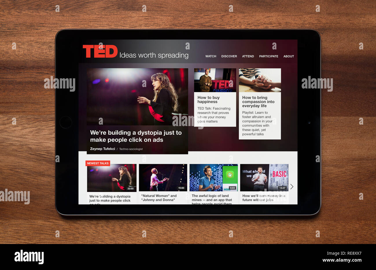 The website of TED is seen on an iPad tablet, which is resting on a wooden table (Editorial use only). Stock Photo