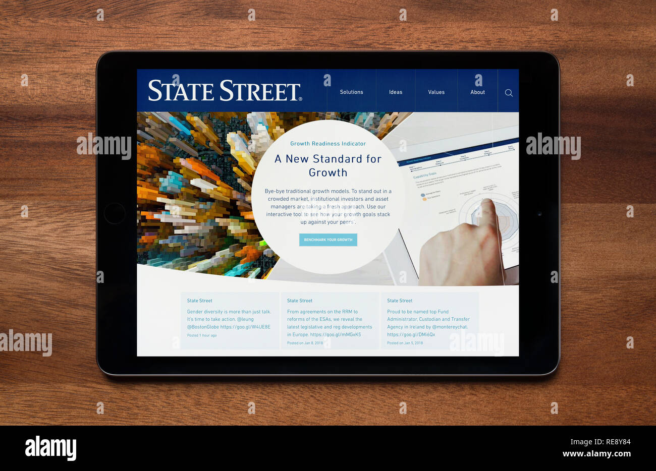 The website of State Street Corporation is seen on an iPad tablet, which is resting on a wooden table (Editorial use only). Stock Photo