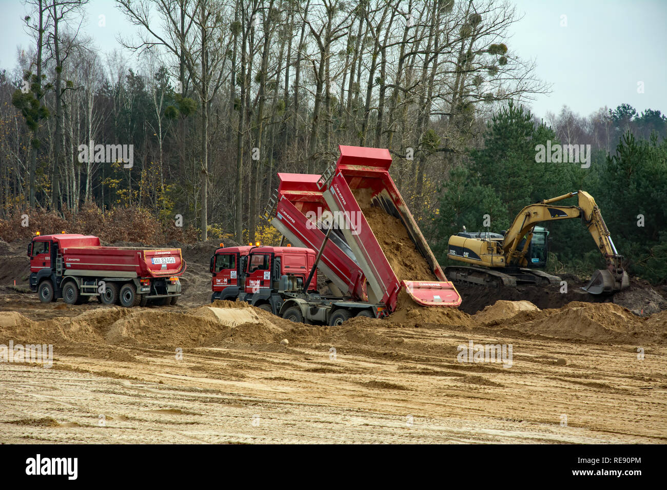 KRUSZYN KRAJENSKI, KUJAWSKO-POMORSKIE/POLAND - NOVEMBER 13, 2017 - S5 construction site with three man kipper dumpers discharging their load and excav Stock Photo