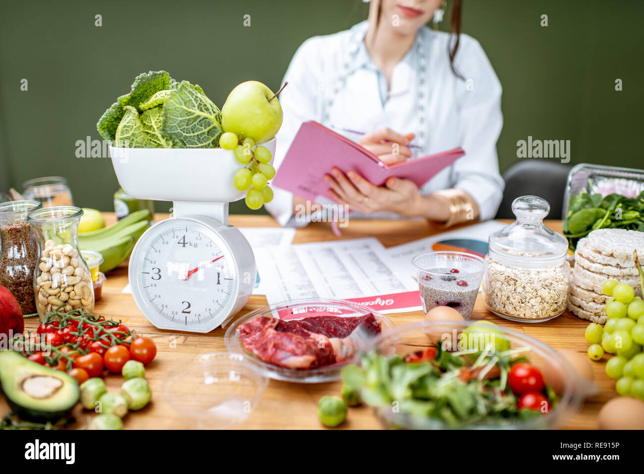 Woman dietitian working on a diet plan sitting with various healthy ...
