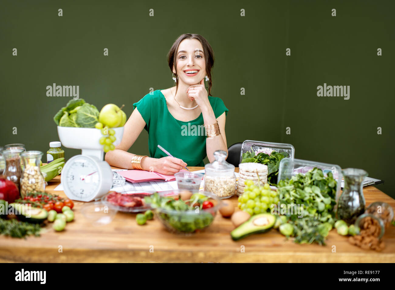 Beautiful woman dietitian working on a diet plan sitting with different ...