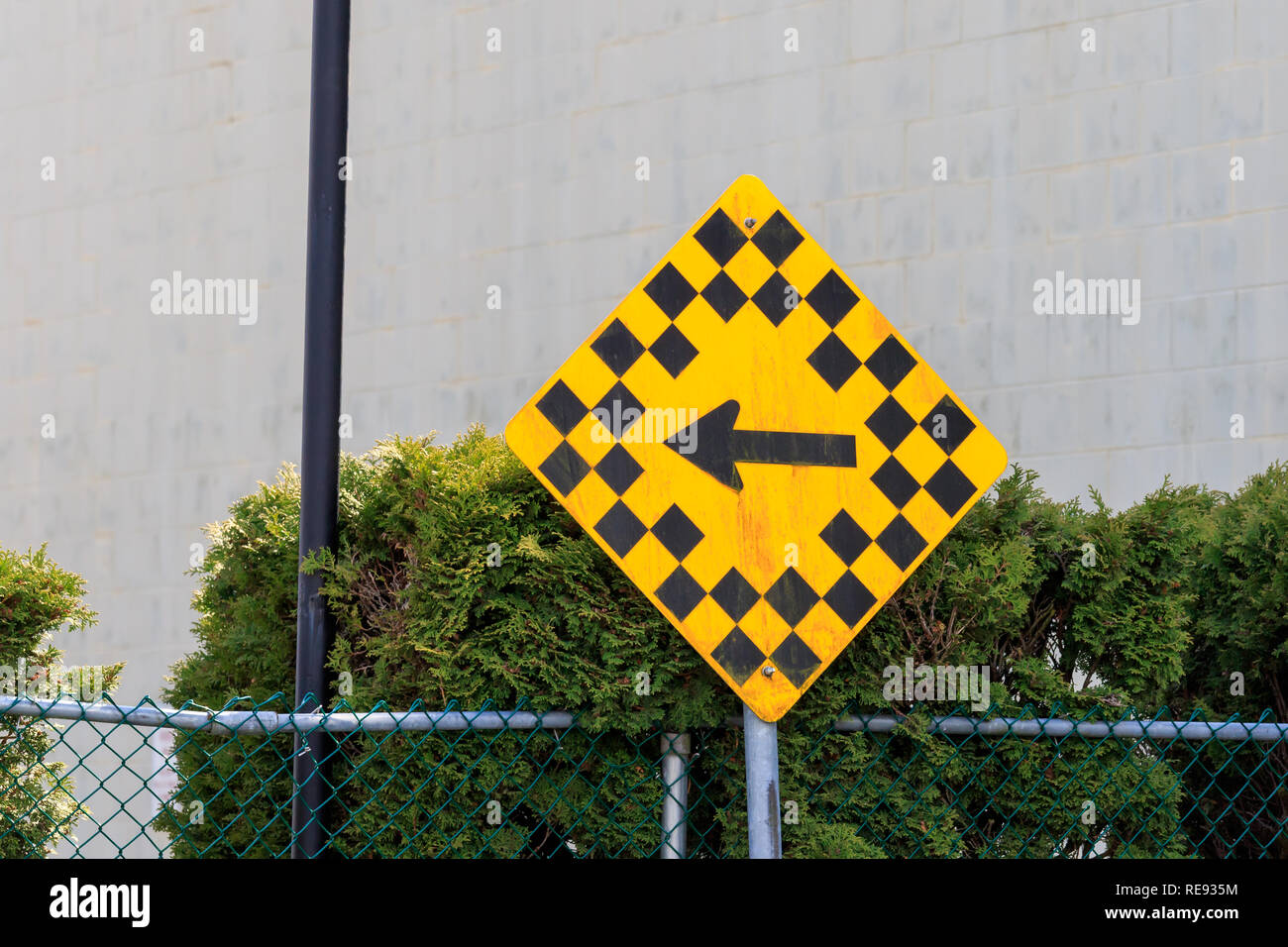 Yellow sign with small back squares and left pointing  black direction arrow Stock Photo
