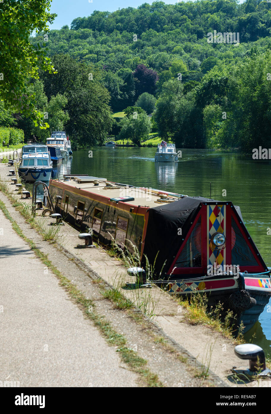 Narrow boat and motor boats moored on the River Thames outside the lock at Goring-on-Thames in the beautiful Thames Valley, England,UK, Stock Photo