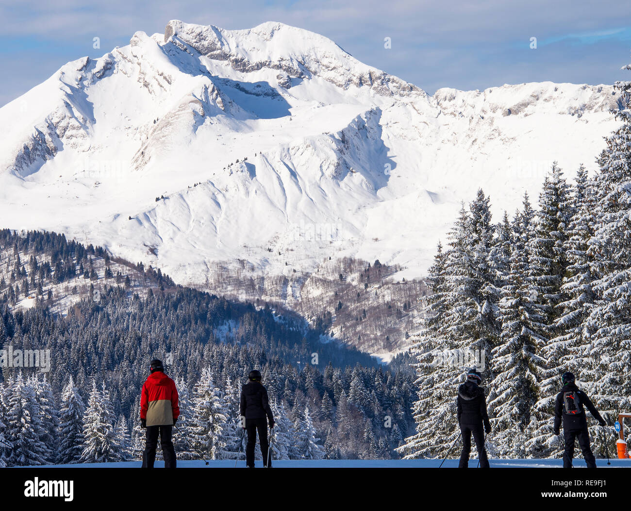 Skiers on the Slopes near Le Pleney Restaurant and Gondola Area with Pine Forest, Roc d' Enfer Mountain Morzine Haute Savoie Portes du Soleil France Stock Photo