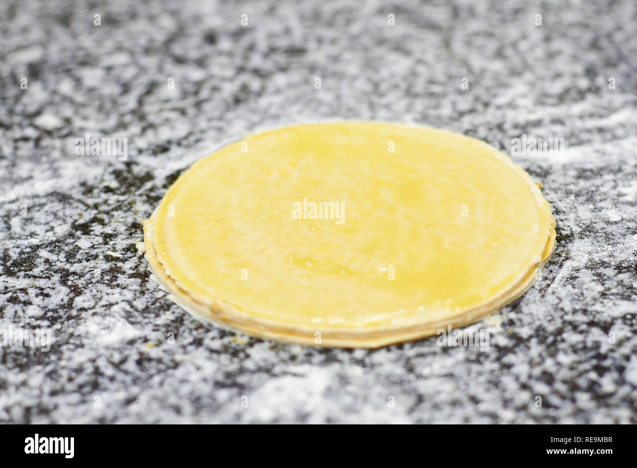 Close up greased round dough on table. Greased round basis. Stock Photo