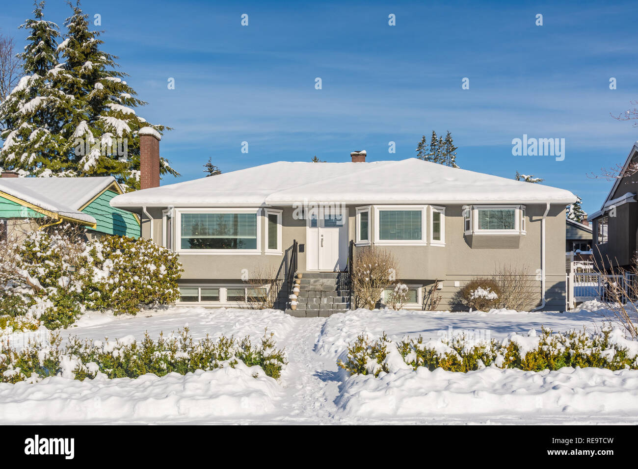 Average residential house in snow on sunny winter day Stock Photo