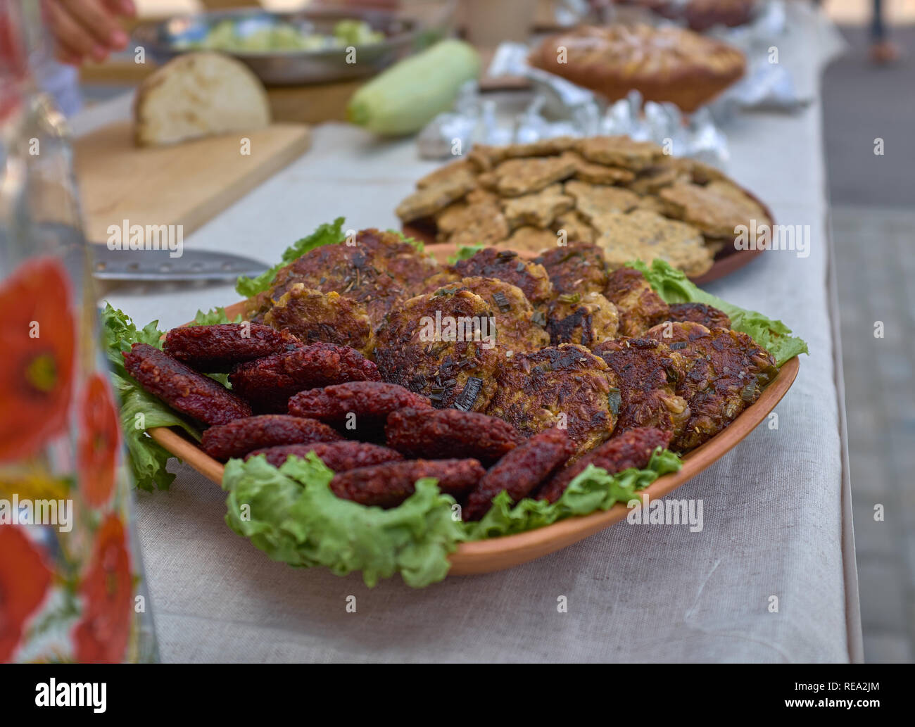Two different meat cutlets and lettuce on a table. Proper nutrition, ideal for everybody. View from side. Close-up. Macro photography. Stock Photo