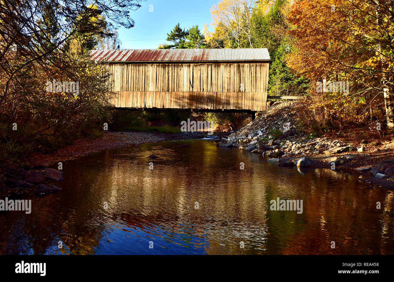 A horizontal side view of the iconic wooden covered bridge spanning the