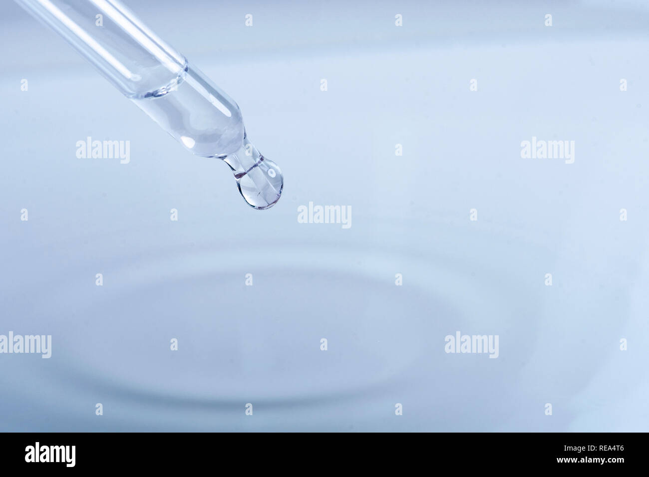 waterdrop with little waves from a pipette Stock Photo