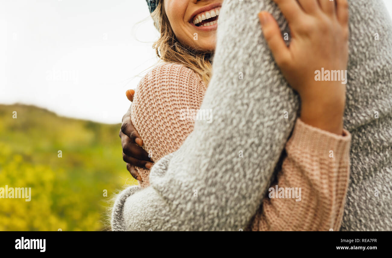 Couple embracing each other with love. Cropped shot of man and woman hugging outdoors. Stock Photo