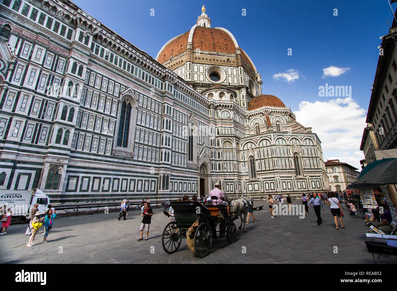 Massive - A horse-drawn carriage passes through a plaza next to the majestic Florence Cathedral. Florence, Italy Stock Photo