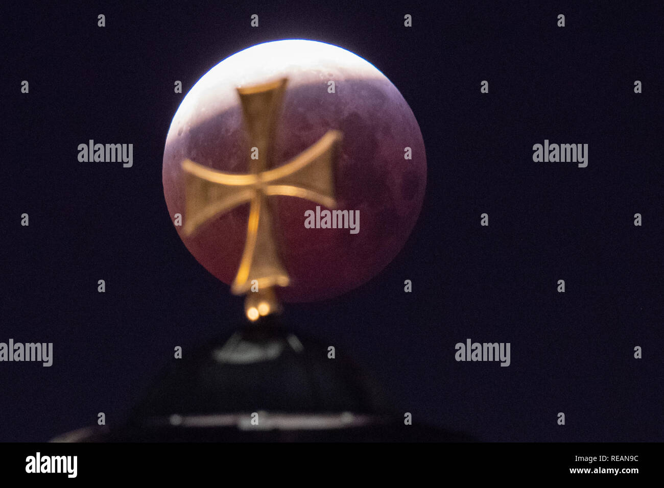 21 January 2019, Bavaria, Nürnberg: As a red, so-called 'blood moon', the full moon stands above the dome of St. Elisabeth's church, while it emerges from the shadow of the earth's core. Photo: Daniel Karmann/dpa Credit: dpa picture alliance/Alamy Live News Stock Photo