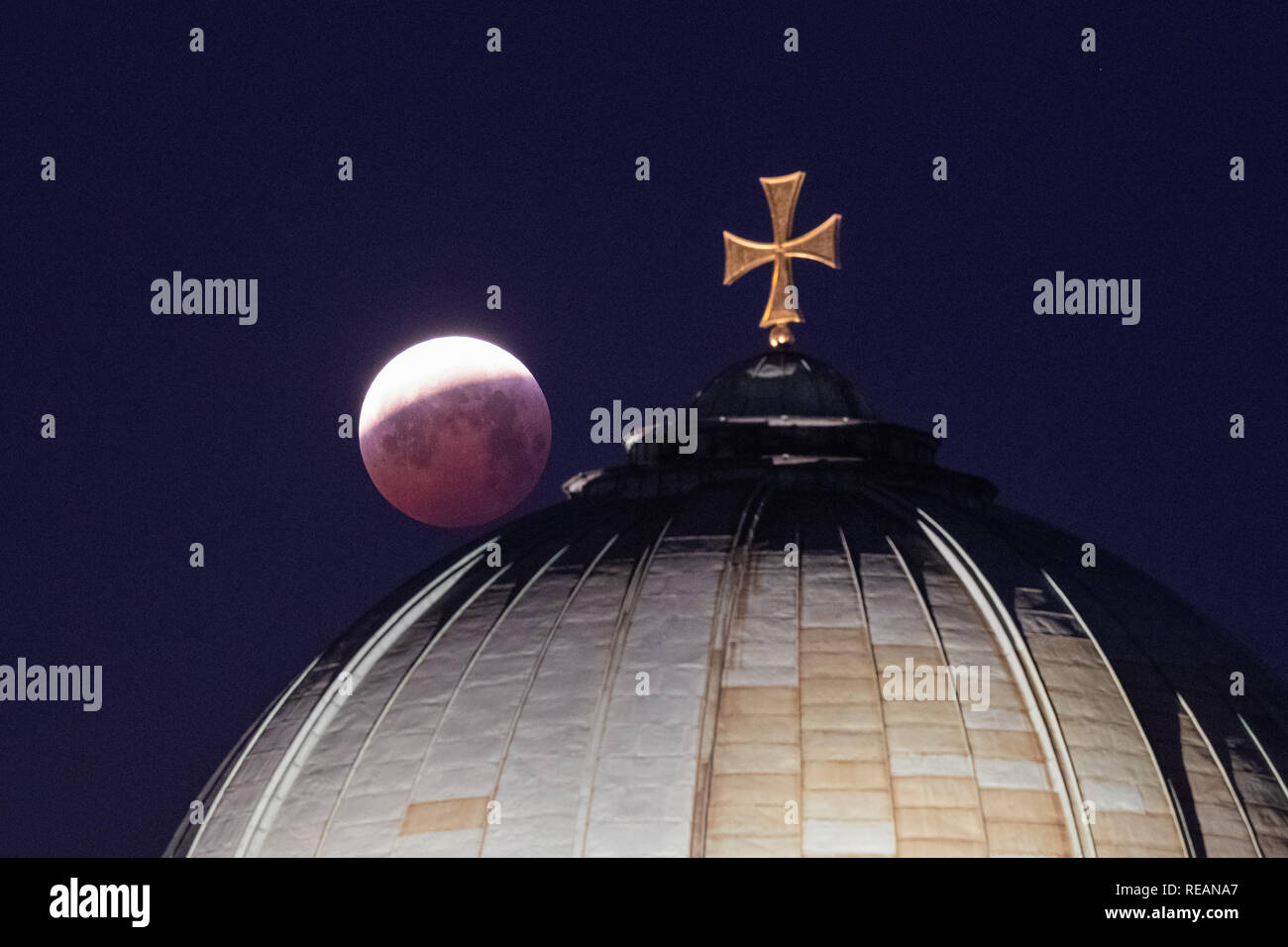 21 January 2019, Bavaria, Nürnberg: As a red, so-called 'blood moon', the full moon stands above the dome of St. Elisabeth's church, while it emerges from the shadow of the earth's core. Photo: Daniel Karmann/dpa Credit: dpa picture alliance/Alamy Live News Stock Photo