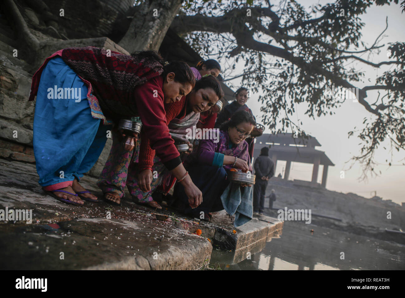 Bhaktapur, Nepal. 21st Jan, 2019. Devotees offer prayers at the bank of the Hanumante River during the Swasthani Brata Katha festival also called Madhav Narayan festival. The month-long festival is to observe fast and pray to Goddess Swasthani and God Madhav Narayan in the hope of a prosperous life and conjugal happiness of their families. Credit: Sunil Pradhan/SOPA Images/ZUMA Wire/Alamy Live News Stock Photo