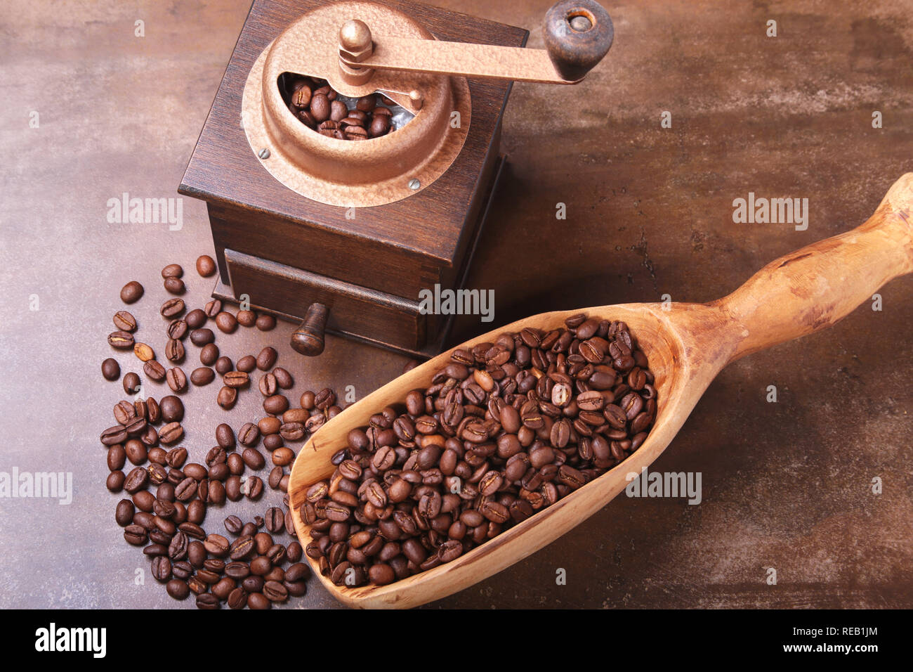 coffee beans in a wooden scoop and coffee grinder on dark stone table. Stock Photo