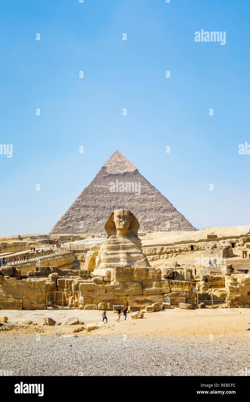 The iconic monumental sculpture, the Great Sphinx of Giza with the Pyramid of Khafre, one of the Great Pyramids, behind, Giza Plateau, Cairo, Egypt Stock Photo