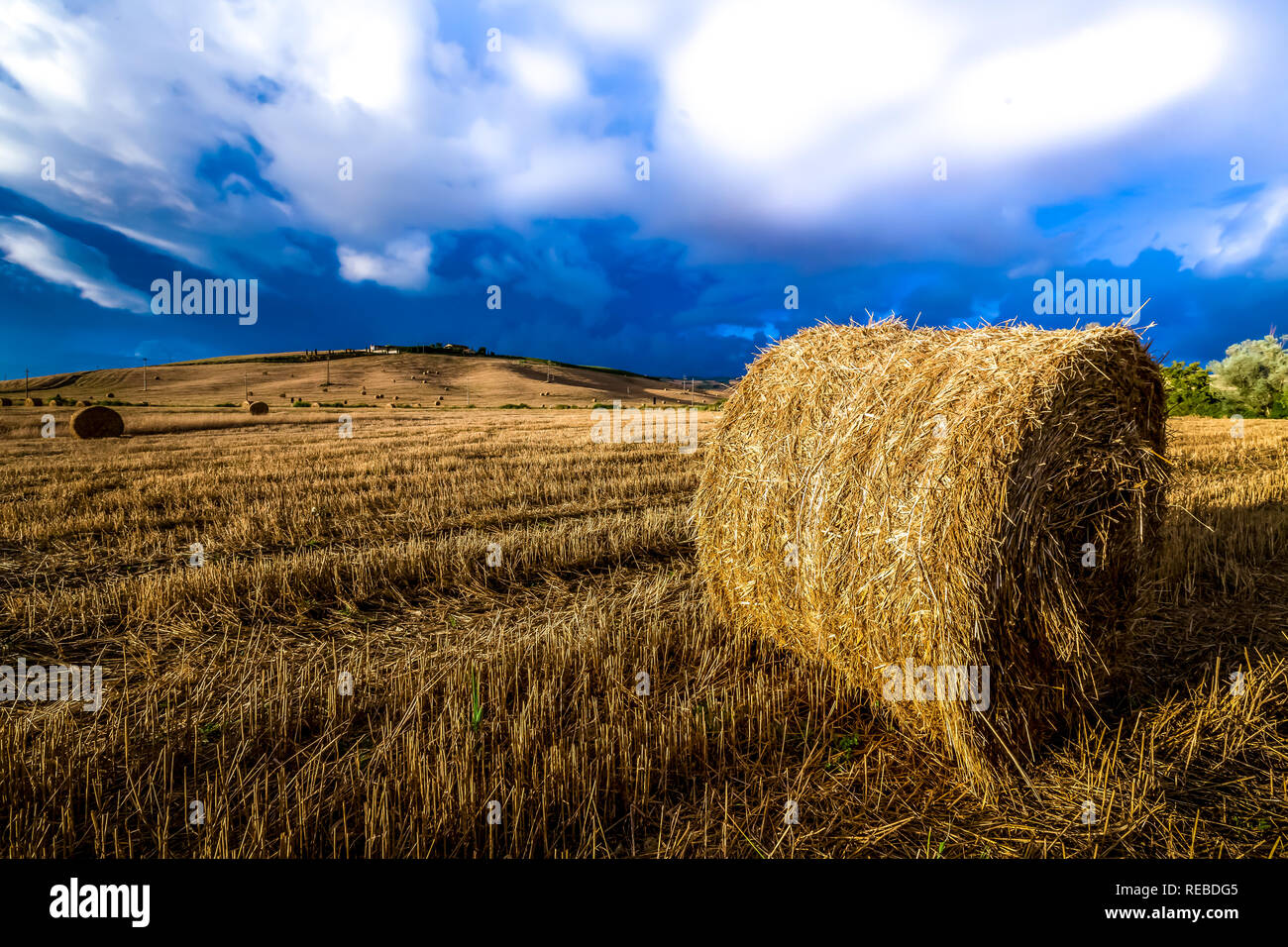 Summer storms rage over recently harvested wheat field Stock Photo