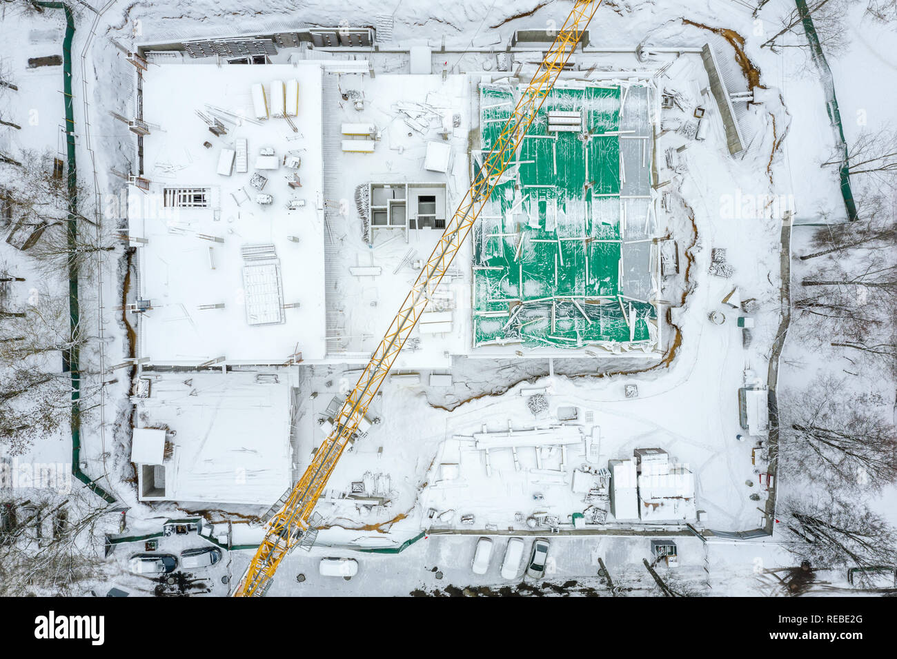 aerial top view of construction site covered with white snow. tower crane building new house Stock Photo
