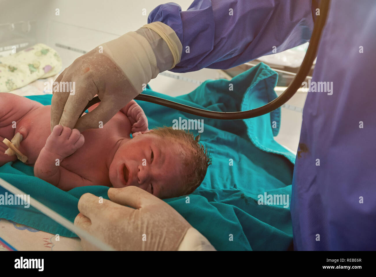 Checking health of newborn baby in clinic delivery room Stock Photo