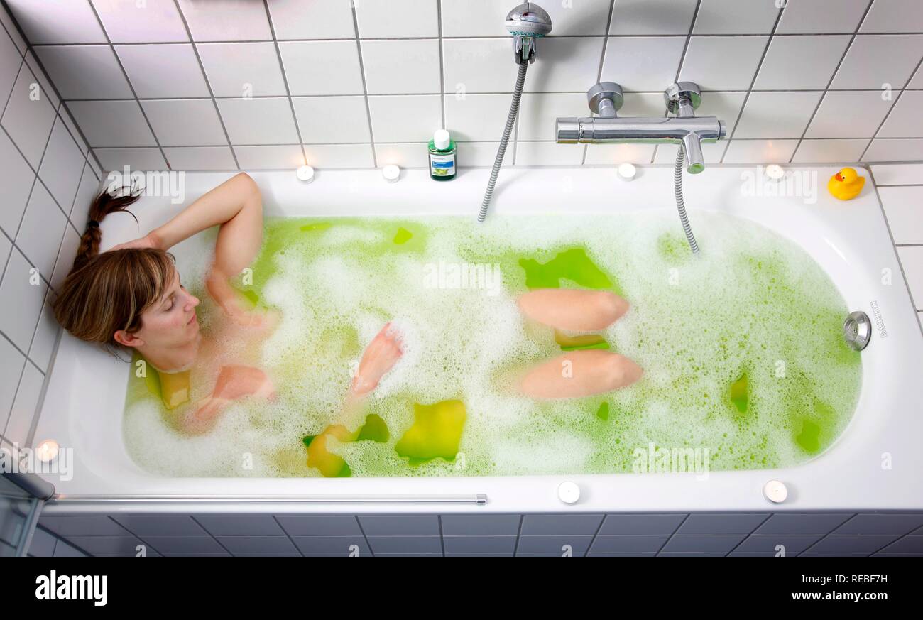 Woman takes a warm bath with a special cold remedy, medical bubble bath Stock Photo