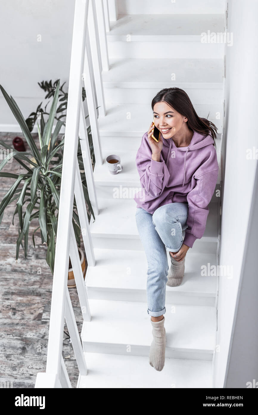Appealing woman wearing jeans and warm socks calling her husband Stock ...