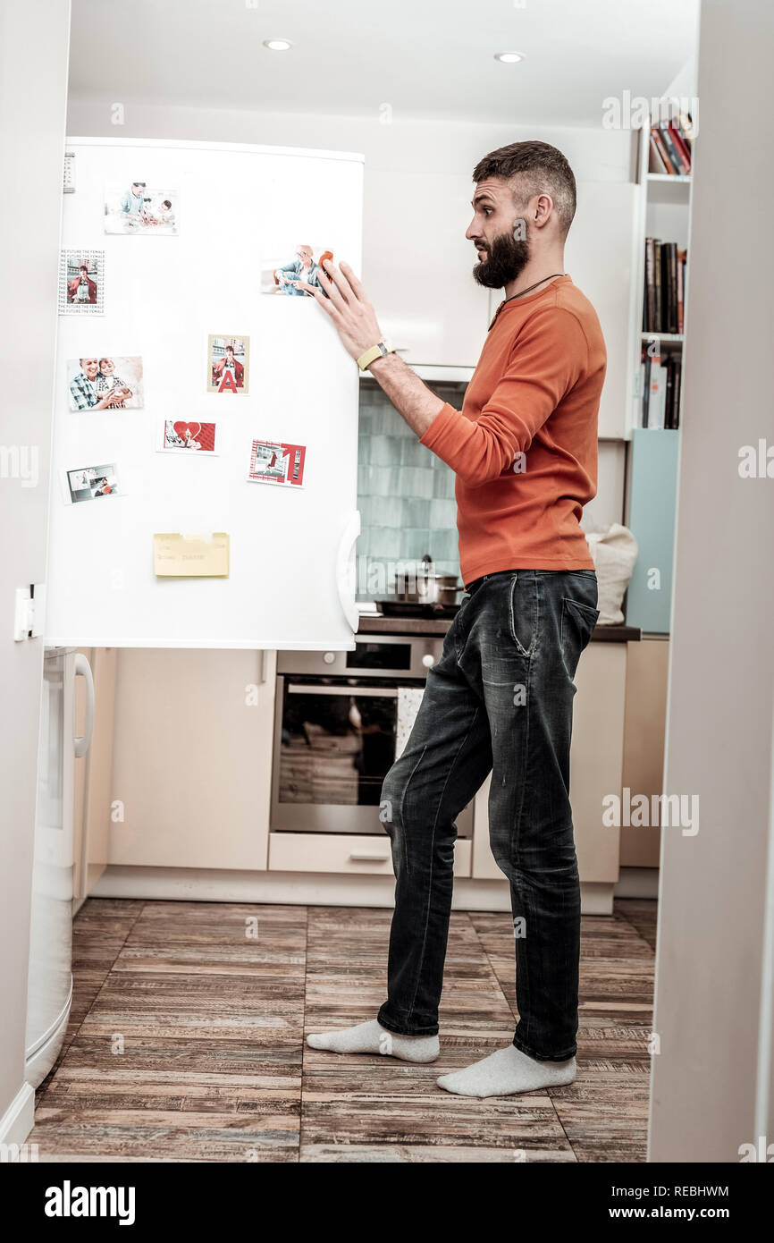 Husband feeling surprised seeing no cooked dinner in refrigerator Stock Photo