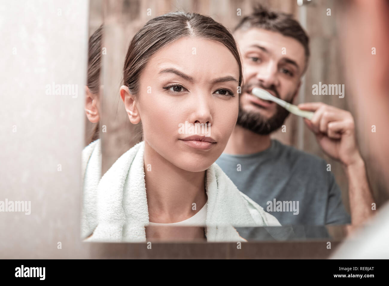 Beautiful young woman removing her makeup in the bathroom Stock Photo