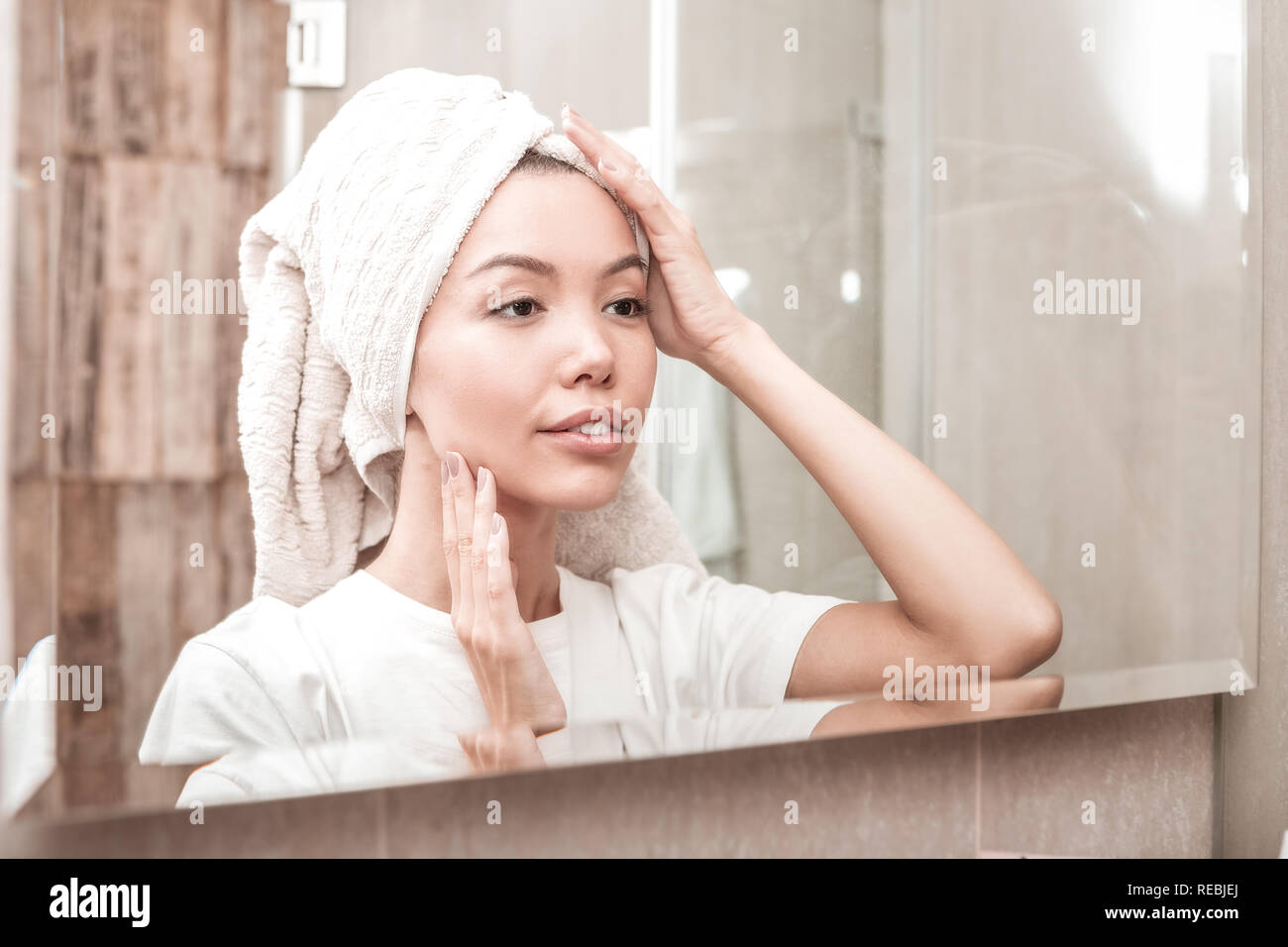 Nice young woman looking at her reflection Stock Photo