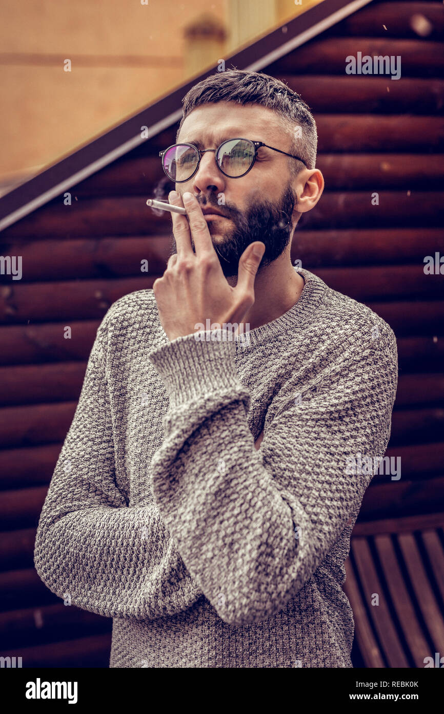 Nice thoughtful man holding a cigarette in his hand Stock Photo