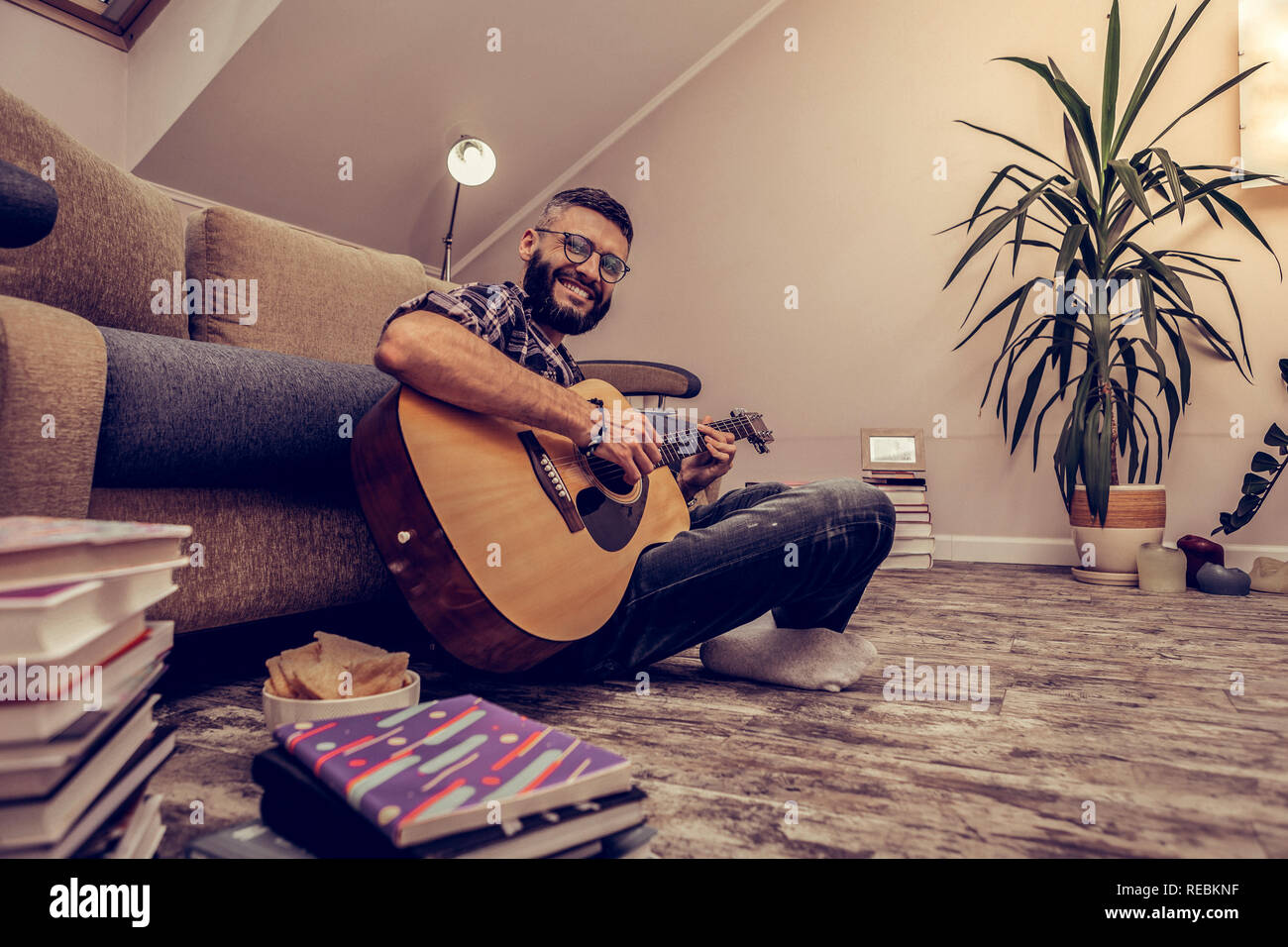 Cheerful happy man sitting with his guitar Stock Photo