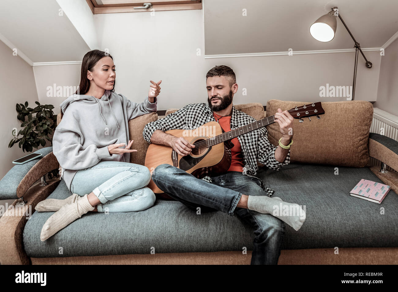 Nice young couple sitting together on the sofa Stock Photo