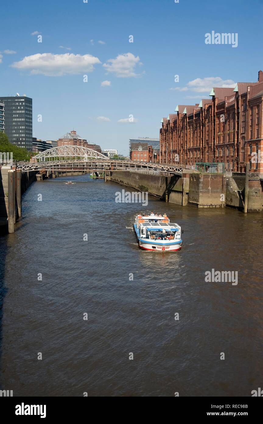 Warehouses along a canal in Hamburg Speicherstadt district, tourist boat Stock Photo