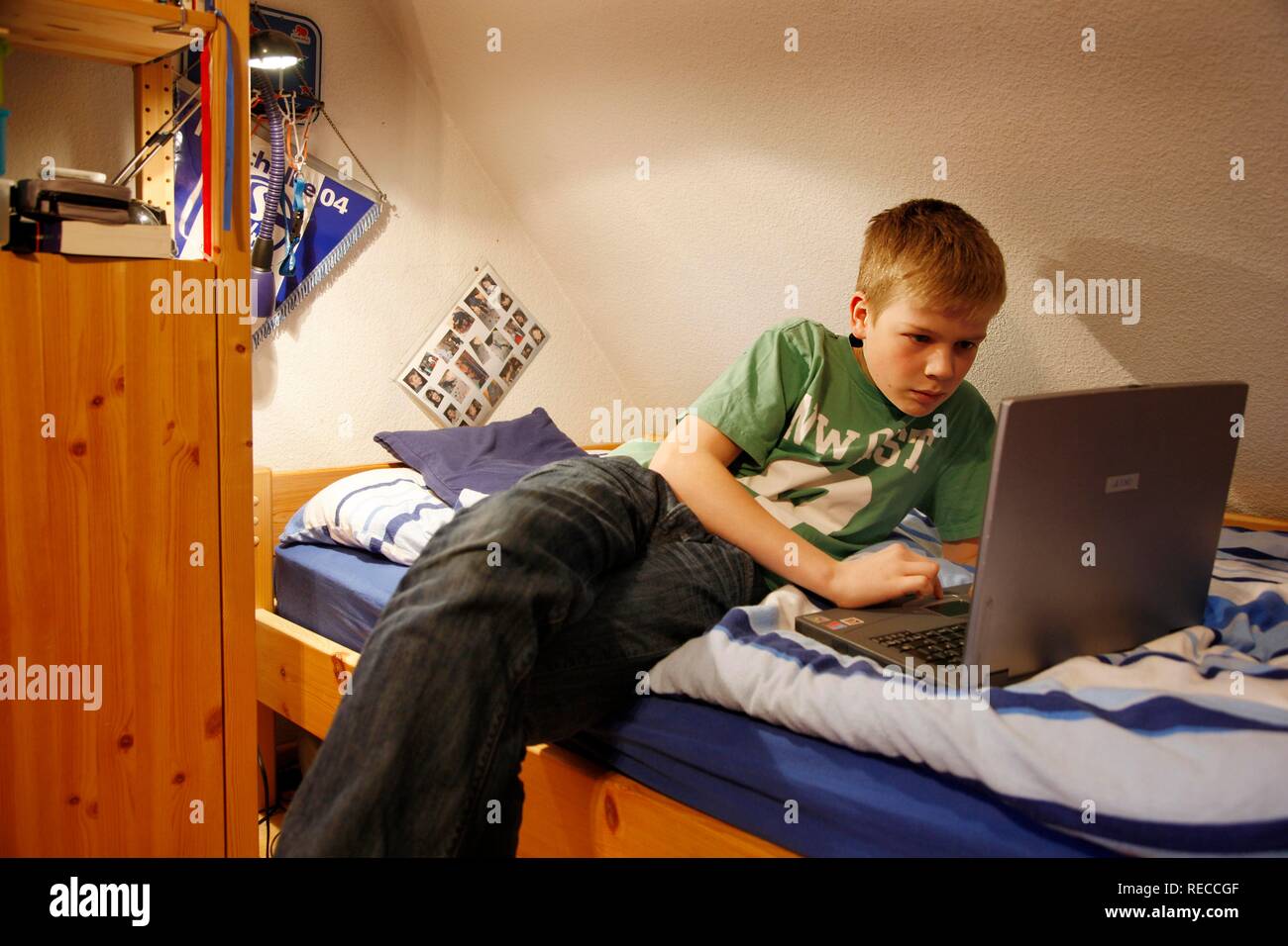 Boy 13 Working With His Computer At Home In His Bedroom While Lying On His Bed Stock Photo Alamy