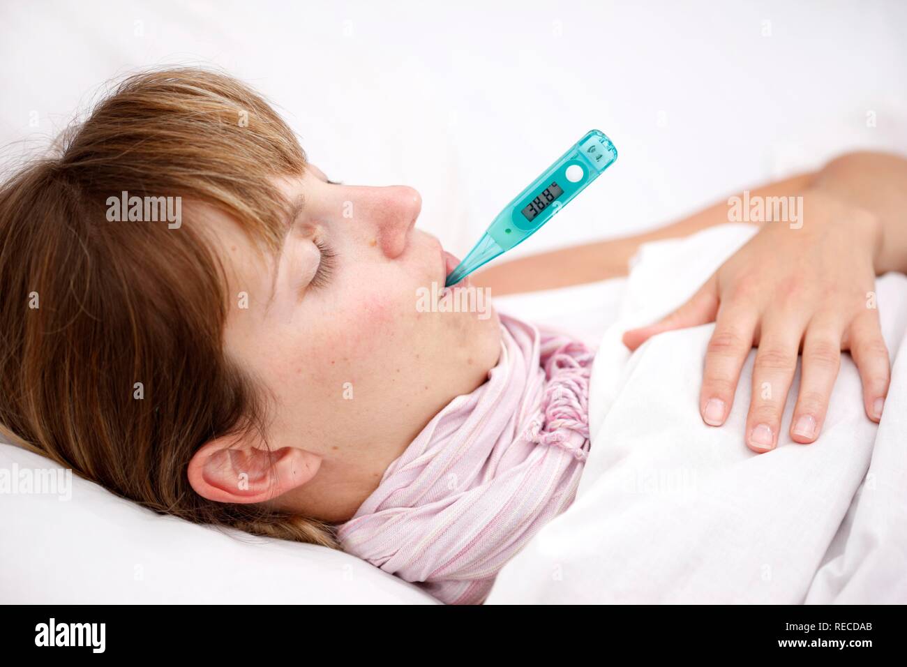 young-woman-sick-in-bed-with-fever-measuring-her-body-temperature