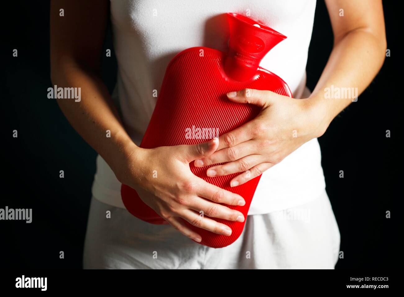 Young woman having abdominal pain, relieving the with a hot