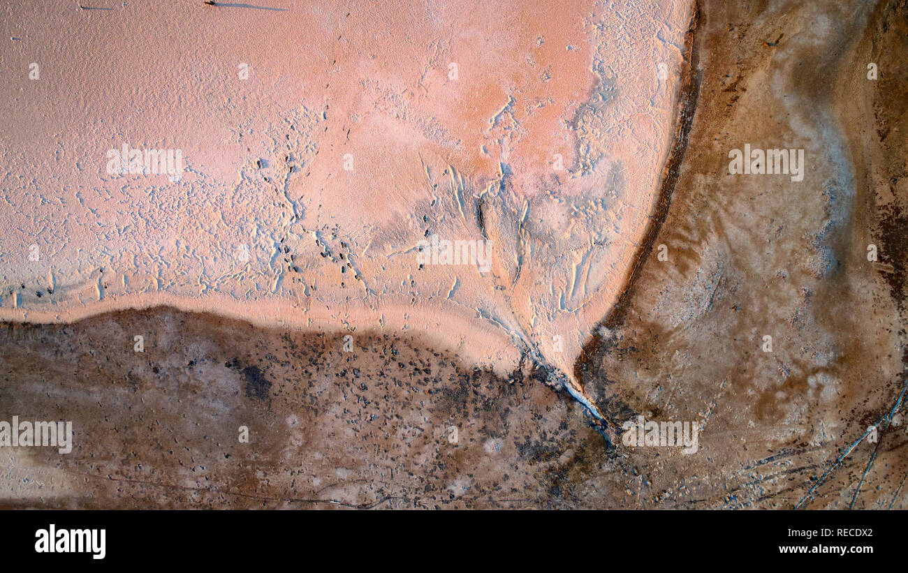 Low altitude aerial image of drying salt lake near Mildura. The white salt is coloured by dust from a storm a week before and also from late afternoon Stock Photo