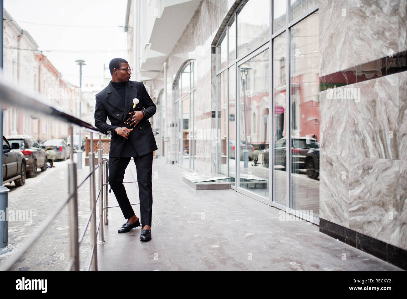 Stylish african american gentleman in elegant black jacket, holding