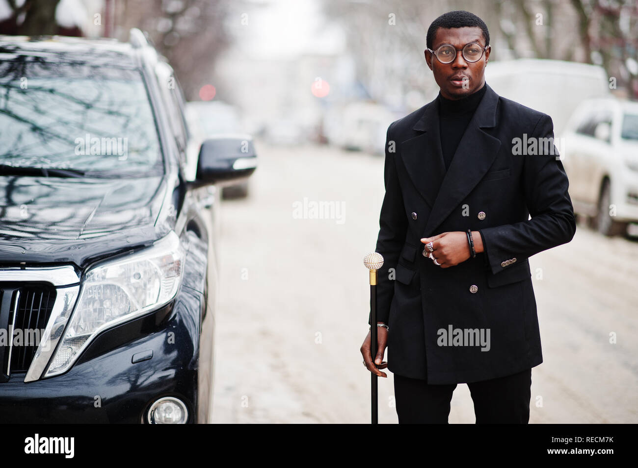 Stylish african american gentleman in elegant black jacket, holding