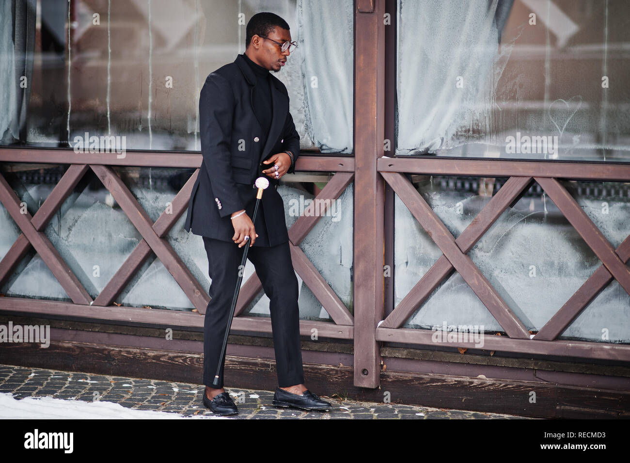 Stylish african american gentleman in elegant black jacket, holding