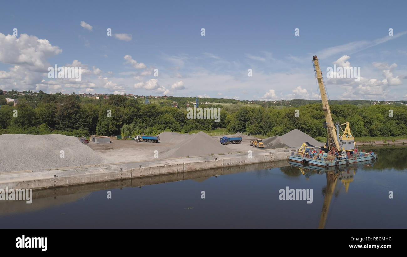 Aerial view large crane an excavator mounted on barge. Excavator on river for unloading and loading sand and rubble. Stock Photo