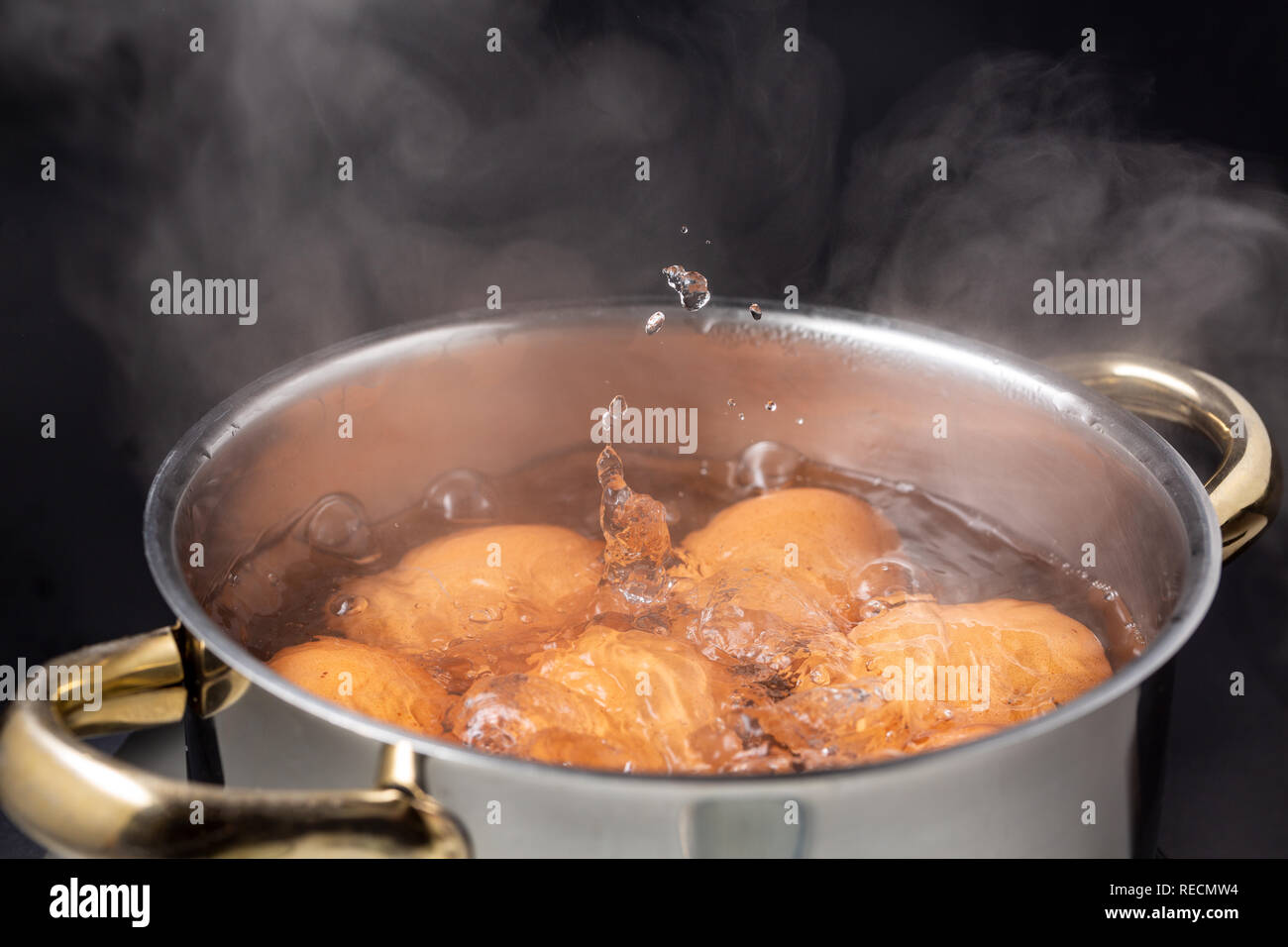 cooking brown chicken eggs in boiling steaming water on electric stove